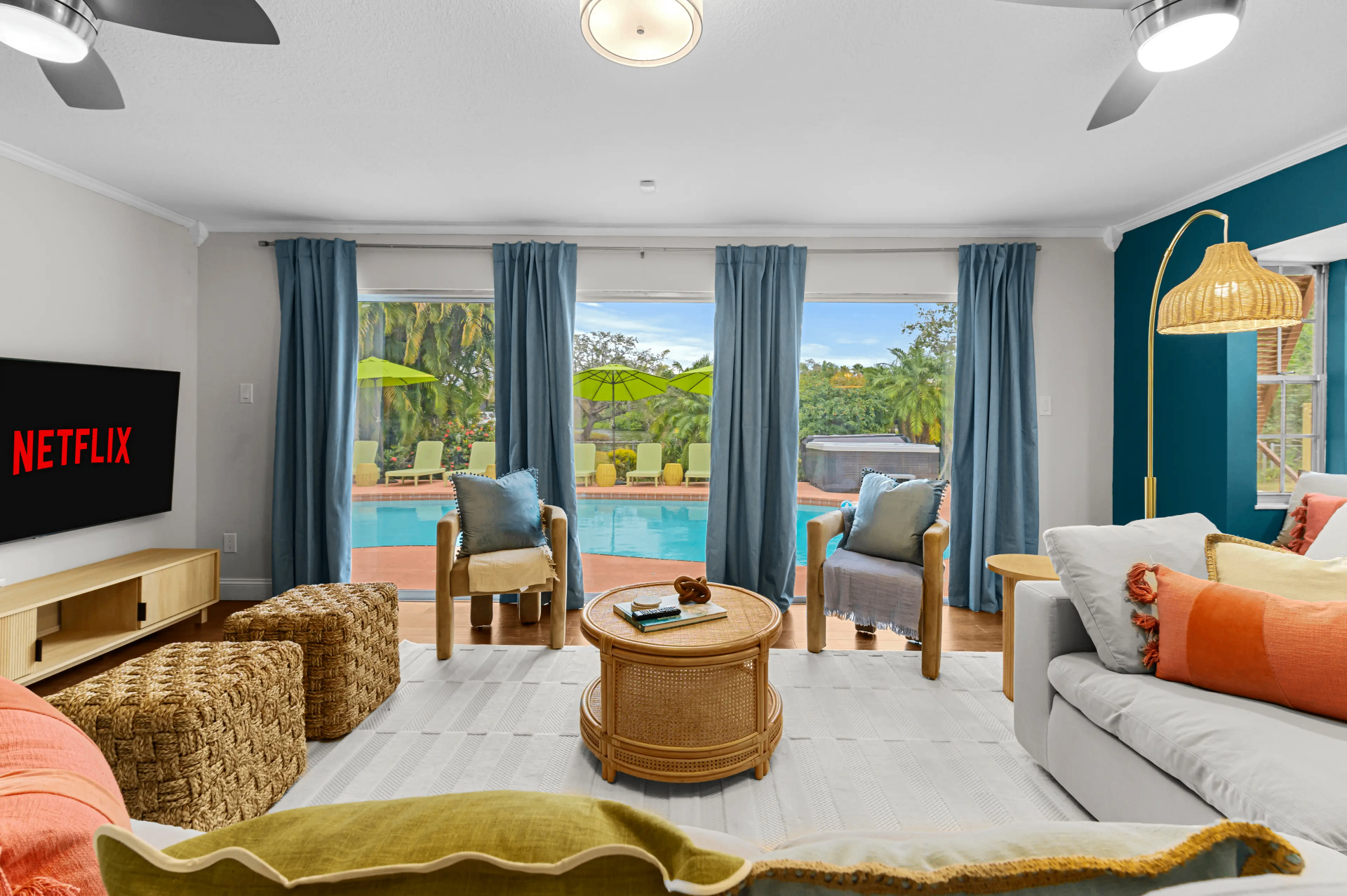 Beautiful modern living room with large glass windows overlooking a custom pool and backyard